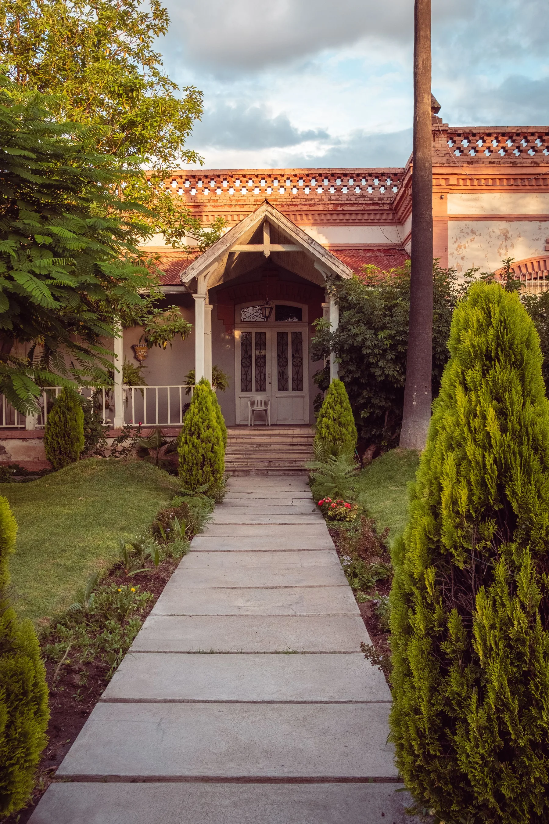 Concrete walkway through a landscaped yard; illustrative stock image
